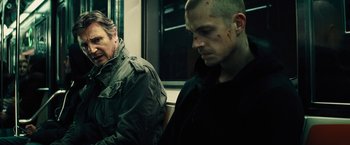 Movie still from “Run All Night” (2015), directed by Jaume Collet-Serra – Two men on a train with blood on their faces; Medium shot, Over the shoulder angle