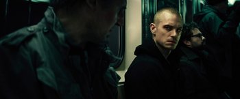 Movie still from “Run All Night” (2015), directed by Jaume Collet-Serra – Two men are sitting on a train looking at each other; Close Up shot, Over the shoulder angle