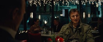 Movie still from “Run All Night” (2015), directed by Jaume Collet-Serra – A group of people sitting at a table in a restaurant; Medium shot, Over the shoulder angle