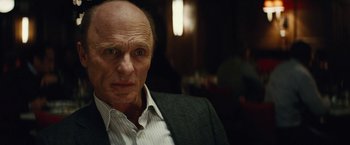 Movie still from “Run All Night” (2015), directed by Jaume Collet-Serra – An older man wearing a suit and tie; Close Up shot, Over the shoulder angle