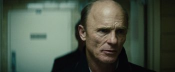 Movie still from “Run All Night” (2015), directed by Jaume Collet-Serra – A man with a bald head looking at the camera; Close Up shot, Low angle