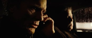 Movie still from “Run All Night” (2015), directed by Jaume Collet-Serra – An old man is talking on a cell phone in the dark; Close Up shot, Low angle