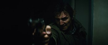 Movie still from “Run All Night” (2015), directed by Jaume Collet-Serra – A man holding a gun in a dark room; Close Up shot, Low angle