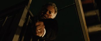 Movie still from “Run All Night” (2015), directed by Jaume Collet-Serra – A man in a suit and tie pointing at the camera; Close Up shot, Low angle