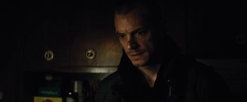 Movie still from “Run All Night” (2015), directed by Jaume Collet-Serra – A person in a dark room; Close Up shot, High angle