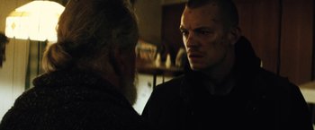 Movie still from “Run All Night” (2015), directed by Jaume Collet-Serra – A man looking into a mirror while standing next to an older man; Close Up shot, Over the shoulder angle