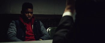 Movie still from “Run All Night” (2015), directed by Jaume Collet-Serra – A man sitting at a table in front of another man; Close Up shot, Over the shoulder angle