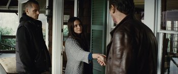 Movie still from “Run All Night” (2015), directed by Jaume Collet-Serra – A man and a woman shaking hands in a doorway; Medium shot, Over the shoulder angle