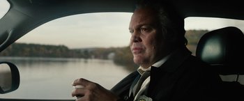 Movie still from “Run All Night” (2015), directed by Jaume Collet-Serra – A man sitting in the driver's seat of a car looking out the window; Close Up shot, Over the shoulder angle