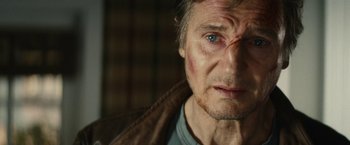 Movie still from “Run All Night” (2015), directed by Jaume Collet-Serra – A man's face with a bruise on his eye; Close Up shot, Over the shoulder angle