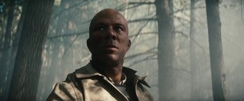 Movie still from “Run All Night” (2015), directed by Jaume Collet-Serra – A bald man in a jacket looking up at the sky; Close Up shot, Low angle