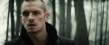 Movie still from “Run All Night” (2015), directed by Jaume Collet-Serra – A person in a forest; Close Up shot, Over the shoulder angle