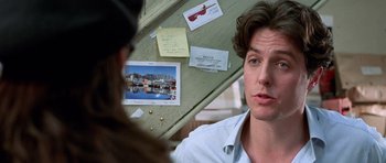 Movie still from “Notting Hill” (1999), directed by Roger Michell – A man is talking to a woman in front of a bulletin board; Close Up shot, Over the shoulder angle