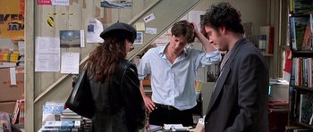 Movie still from “Notting Hill” (1999), directed by Roger Michell – A group of people standing next to each other in a room; Medium shot, Over the shoulder angle