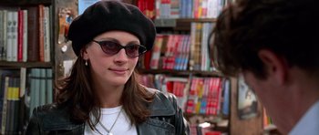 Movie still from “Notting Hill” (1999), directed by Roger Michell – A woman wearing sunglasses and a hat in a store; Close Up shot, Over the shoulder angle