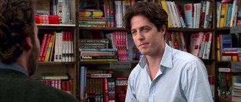 Movie still from “Notting Hill” (1999), directed by Roger Michell – A man in front of a book shelf in a library; Close Up shot, Over the shoulder angle