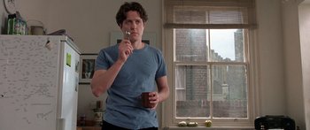 Movie still from “Notting Hill” (1999), directed by Roger Michell – A man holding a cup in his right hand; Close Up shot, Low angle