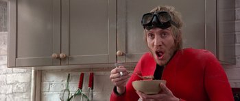 Movie still from “Notting Hill” (1999), directed by Roger Michell – A man wearing goggles eating a bowl of food; Medium shot, Low angle