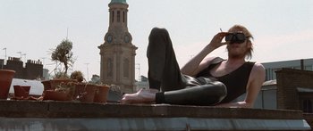 Movie still from “Notting Hill” (1999), directed by Roger Michell – A woman laying on the ground smoking a cigarette; Medium shot, Low angle