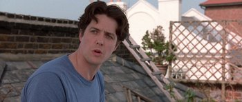 Movie still from “Notting Hill” (1999), directed by Roger Michell – A young man is standing on the roof of a building; Close Up shot, Low angle