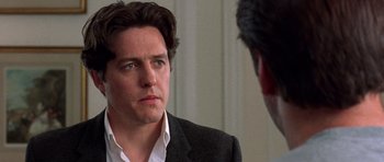 Movie still from “Notting Hill” (1999), directed by Roger Michell – A person wearing a suit and tie; Close Up shot, Over the shoulder angle