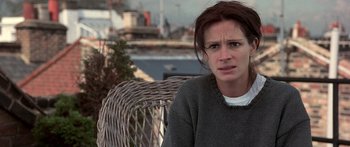 Movie still from “Notting Hill” (1999), directed by Roger Michell – A person sitting on a chair; Close Up shot, Over the shoulder angle
