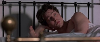 Movie still from “Notting Hill” (1999), directed by Roger Michell – A man laying in a bed with his head on his hand; Close Up shot, Low angle