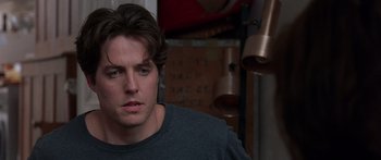 Movie still from “Notting Hill” (1999), directed by Roger Michell – A person wearing a gray t - shirt; Close Up shot, Over the shoulder angle