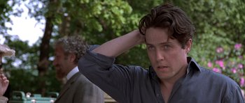 Movie still from “Notting Hill” (1999), directed by Roger Michell – A young man with blue eyes is scratching his head; Close Up shot, Over the shoulder angle