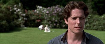 Movie still from “Notting Hill” (1999), directed by Roger Michell – A person in a field near a bush; Close Up shot, Over the shoulder angle