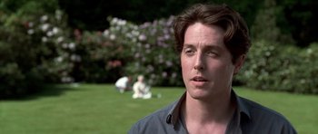 Movie still from “Notting Hill” (1999), directed by Roger Michell – A person in a field near a bush; Close Up shot, Over the shoulder angle