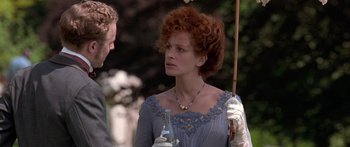 Movie still from “Notting Hill” (1999), directed by Roger Michell – A woman in a blue dress holding an umbrella and talking to a man in a white suit; Close Up shot, Over the shoulder angle