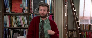 Movie still from “Notting Hill” (1999), directed by Roger Michell – A man with a beard wearing a tie and a cardigan; Medium shot, Low angle