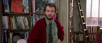 Movie still from “Notting Hill” (1999), directed by Roger Michell – A man wearing a tie and a red cardigan; Medium shot, Low angle