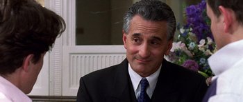 Movie still from “Notting Hill” (1999), directed by Roger Michell – A person wearing a suit and tie; Close Up shot, Over the shoulder angle