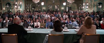 Movie still from “Notting Hill” (1999), directed by Roger Michell – A group of people sitting around a table; Wide shot, Over the shoulder angle