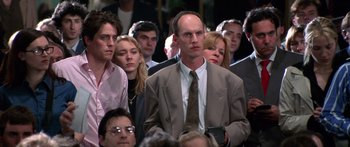 Movie still from “Notting Hill” (1999), directed by Roger Michell – A crowd of people sitting in a room; Medium shot, High angle