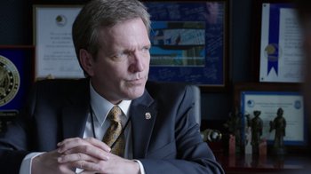 Movie still from “Sabotage” (2014), directed by David Ayer – A person wearing a suit and tie; Close Up shot, Over the shoulder angle