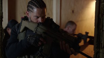 Movie still from “Sabotage” (2014), directed by David Ayer – A man in a black jacket holding a gun; Close Up shot, Over the shoulder angle