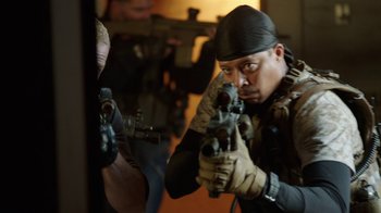 Movie still from “Sabotage” (2014), directed by David Ayer – A man holding a gun in front of a mirror; Medium shot, Over the shoulder angle
