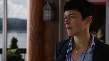 Movie still from “Sabotage” (2014), directed by David Ayer – A woman with short black hair wearing a blue shirt; Close Up shot, Over the shoulder angle