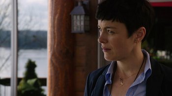 Movie still from “Sabotage” (2014), directed by David Ayer – A person with short hair wearing a suit; Close Up shot, Over the shoulder angle