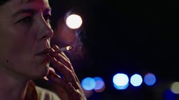 Movie still from “Sabotage” (2014), directed by David Ayer – A woman smoking a cigarette in front of a blurry background; Close Up shot, Low angle
