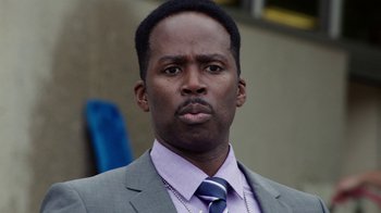 Movie still from “Sabotage” (2014), directed by David Ayer – A man in a suit and tie looking at the camera; Close Up shot, Low angle