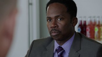 Movie still from “Sabotage” (2014), directed by David Ayer – A person wearing a suit and tie; Close Up shot, Over the shoulder angle
