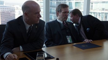 A group of men sitting at a wooden table in a room