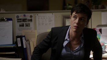 Movie still from “Sabotage” (2014), directed by David Ayer – A woman sitting at a desk; Close Up shot, Over the shoulder angle