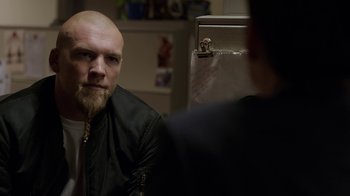 Movie still from “Sabotage” (2014), directed by David Ayer – A man with a bald head looking into a mirror; Close Up shot, Over the shoulder angle