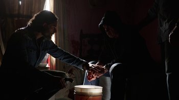 Movie still from “Sabotage” (2014), directed by David Ayer – A man and a woman in a room with a bucket; Medium shot, Low angle