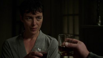 Movie still from “Sabotage” (2014), directed by David Ayer – A woman sitting at a table holding a wine glass; Close Up shot, Over the shoulder angle